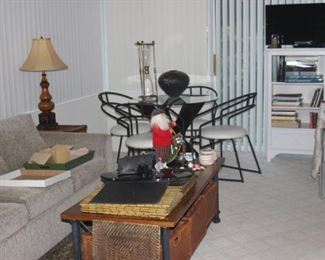 Sunroom, sleeper sofa, contemporary dinette set, bookcase, art books, Samsung TV, coffee table.