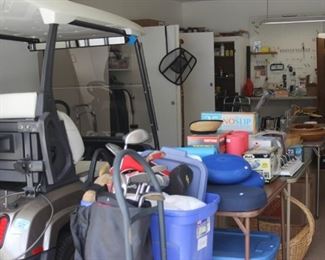 Garage full of tables and cabinets of all kinds of things.