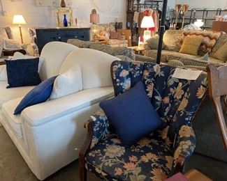 White loveseat and floral high back chair