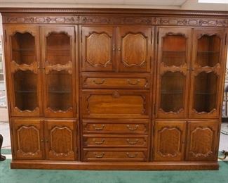 1022	CHERRY FRENCH PROVINCIAL BOOKCASE WALL UNIT HAVING A CENTER MIRRORED BAR & DESK UNIT & INTERIOR GLASS SHELVES W/LIGHTING, APPROXIMATLEY 116 IN WDE X 19 IN DEEP X 84 IN HIGH, 3 SECTIONS W/TOP & BASE
