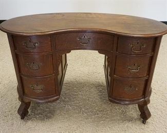 1043	OAK KIDNEY SHAPED DESK W/REEDED FRONT COLUMNS, APPROXIMATLEY 48 IN X 3 IN X 31 IN HIGH, STAINING ON TOP SURFACE
