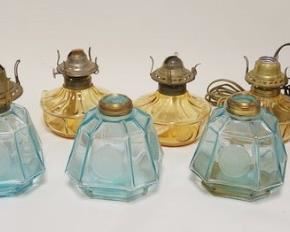 1298	11 FOSTORIA COIN LAMPS, 4 LIGHT BLUE & 7 AMBER, 3 ARE ELECRIC, 3 DON'T HAVE BURNERS
