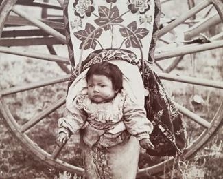 Original 1800s  7" x 5" photograph of a Shoshone baby on a beautiful cradle board, signed by the photographer "Chief Washakie's Grand Daughter". The photographer was George W. Scott of Lander, Wyoming (Born 1854). Measures 7" x 5" on a 9" x 7" backer board.