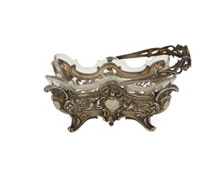 1101
A German Silver And Cut Crystal Basket
Late 19th/Early 20th Century
With German 800 silver marks; Further marked: Seligmann J.
The handled silver basket with repousse floral motifs and cut crystal insert
8" H x 7.5" W x 5.375" D
10.68 oz. troy approximately
Estimate: $500 - $700