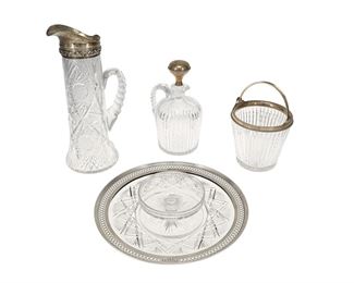 1168
A Group Of American Brilliant Cut Glass And Sterling Silver Items
First Half 20th Century
Each marked for sterling and various makers
With various cut-glass motifs, comprising a tall handled carafe sterling spout (12.875" H x 5.75" W x 5" D), an ice bucket with sterling collar and handle (6" H x 5.625" Dia.), a decanter jug with sterling stopper (9.375" H x 5.5" W x 4.75" D), and a tiered centerpiece tray with and pierced sterling rim (3" H x 12" Dia.), makers include Reed & Barton, 4 pieces
197.1 gross oz. troy approximately
Estimate: $400 - $600
