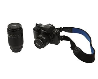 1227
A Nikon N6006 (F-601) 35mm SLR Camera
Circa 1990-1994
The Nikon SLR camera (serial no. 2455551) with a built-in pop-up electronic flash, motor driven automatic film advance, predictive autofocus, 2 fps shooting speed, 1/2000 shutter speed, and a 35-70mm autofocus Nikkor zoom lens (serial no. 4114211), accompanied by an interchangeable 70-210 Nikkor zoom lens (serial no. 2456868), and with black leather camera case and drawstring 70-210mm lens bag, 4 pieces
Camera: 3.75" H x 6" W x 5" D
Estimate: $200 - $300