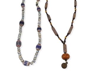 1284
Two African Trade Bead Necklaces
20th Century
Each with polychrome trade beads, one suspending a bronze circular bell charm, 2 pieces
Larger: 32" C, drop: 4" L; Smaller: 32.5" C
Estimate: $300 - $500
