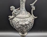 Italian Figural Ewer with Cherubs and a lovely mermaid with wings! What a lovely unique design.

One side has some type of glue or varnish on the middle. Unknown if removable. Measures 18” high and 8” wide at the top handle.