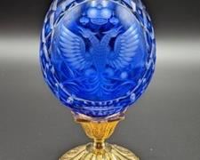 Cobalt Faberge Imperial Crest Crystal Egg. Numbered piece has some light paint wear on the gold tone base, but in otherwise great condition. Measures 7” high and 3.5” wide.v