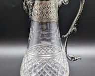 Crystal and Silver Plate Claret Pitcher with Figural Lip. Measures 12” high and 6” wide at the top handle.