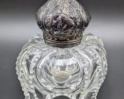 Vintage Sterling Topped Cut Glass Bottle. The sterling top features a detailed design.  There is some slight splitting on the sterling top seam. Measures 4” x 4” and 5” high.