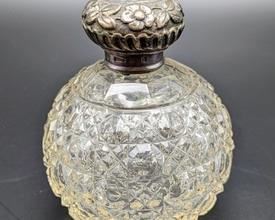 Vintage Floral Silver Topped Perfume Bottle. It does appear to be sterling, however no sterling marks were found. See photos for hallmarks.

 Measures 4” high and 3.5” wide.