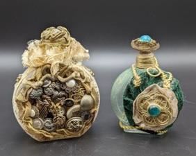 Pair of Vintage Fabric Covered/Embellished Perfume Bottles. One has some wear on the netting that can be seen in the photos. The largest measures 4.5” high and 3.5” wide