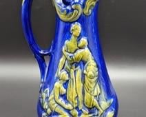 Vintage Blue Ceramic Pitcher. A pretty pop of yellow-green! There is a scuff on the upper rim that can be seen in the photos. Measures 10” high and 6” wide at the base.