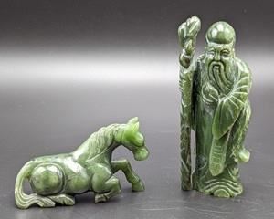 Pair of Carved Nephrite Jade Figurines. There are some hairline cracks on the base of the scholar figurine. The tallest measures 5” high and 2” wide.