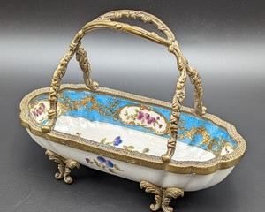 Handled Chinese Porcelain Footed Dish. A petite dish in pretty gold and blues! There is some light wear on the brass and a discoloration on the bottom of the dish that can likely be cleaned off. Measures 3” x 7” and 5” high.