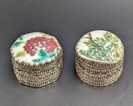 Pair of Chinese Porcelain Topped Trinket Boxes. Appears to be made of vase shards. Each measures 1” high and 1.5” in diameter.