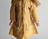 K an R Butler Reproduction Doll. Marked 117. There is a snag on her socks and light wear to the shoes. Measures 12” high.