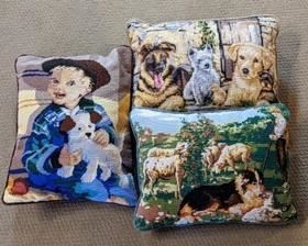 Three Doggie Themed Needlepoint Pillows. All look to be in great condition and the largest measures 13” x 18”. All are handcrafted with amazing details! 