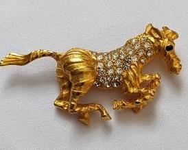 Vintage Gold Tone Horse Brooch with Rhinestones. There are no maker markings. Measures 1” x 2.5”