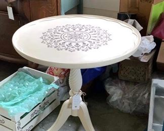 Heavy round off-white table with stenciling on top