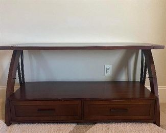 Large TV stand with two drawers, glass shelf and TV mounting bracket that rises and lowers. Measures 52 inches wide by 18 inches diameter by 38 inches high without TV