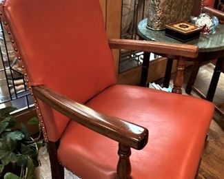 One of three matching orange leather arm chairs