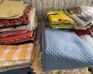 many bolts and cuts of fabric, including upholstery fabric