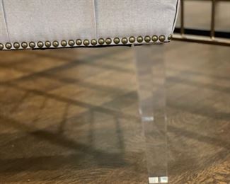 Linen upholstered bench with nailhead trim and lucite legs. Measures 48" x 18" D x 18" H. Photo 3 of 3.