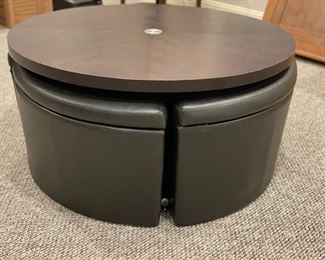 Cocktail table with four hide-away leather storage seats. Table can be raised to create a dining surface. Table measures 40" D. Photo 1 of 3.