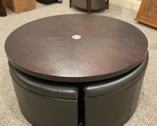 Cocktail table with four hide-away leather storage seats. Table can be raised to create a dining surface. Table measures 40" D. Photo 2 of 3.