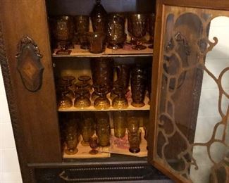 Large collection of Fostoria amber glassware in vintage China cabinet