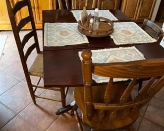 mahogany drop leaf table shown with odd chairs 