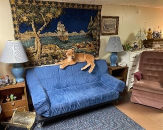 Mid century sofa with adjustable arms, back lays down to make a bed in a crushed blue velvet upholstery, matching mid century end tables by American of Martinsville, crushed velvet tapestry wall hanging. 