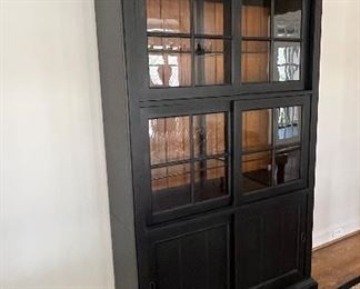 Ethan Allen New Country Collection. "Webber" China Cabinet. High Quality American Made Distressed Black Painted China Current retail over $5,000.00! Our price $1,800.
Cabinet with Dimmable Lighted Interior, Glass Shelves and Sliding Doors. Height: 7 feet. Width at top molding is 54". Width of cabinet body is 48". Backing of Walnut Beadboard. PRICE $ 1800