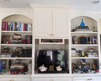 Bookshelf area in the sunroom, with amazing book selection, cast iron toys, seashells and scotty dog collection.