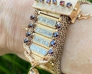 K - Retro gold bracelet : Solid 14kt gold yellow buckle themed retro bracelet set with round garnets and diamonds and a tassel at the end of the bracelet. There is a fold over clasp, figure 8 safety. and also a safety chain. 78 grams. $2,650. Appraisal included. 