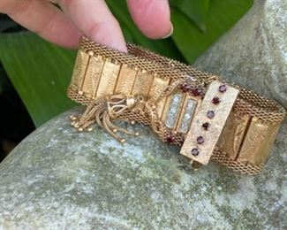 K - Retro gold bracelet : Solid 14kt gold yellow buckle themed retro bracelet set with round garnets and diamonds and a tassel at the end of the bracelet. There is a fold over clasp, figure 8 safety. and also a safety chain. 78 grams. $2,650. Appraisal included. 