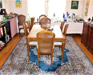 Dining room is full of furniture, bookcases, artwork, glassware and china.  