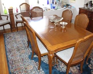 Dining room table with eight chairs, two are arm chairs.