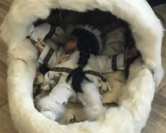 Sweet doll in rabbit pelt cover bed.