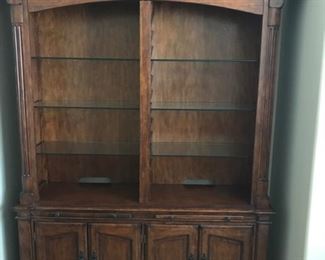 This is an amazing curio cabinet with with glass shelves to display your collectibles.  It has lights at the top with storage behind doors at the bottom. Very nice wood finish.