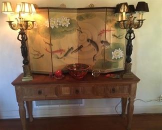 Folding Silk screen, Figural lamps on rustic wood sofa table. LAMPS ARE SOLD