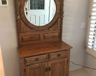 Beveled mirrored cabinet with coat hooks and storage