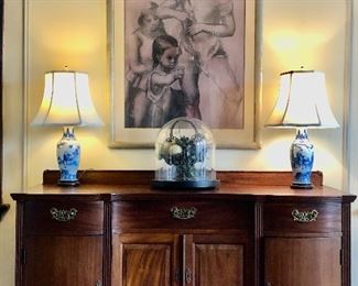 Dining Room:  A large charcoal drawing by listed artist Jon Corbino hangs above an antique sideboard (59" wide x 40" tall to back center carved shell x 24" deep). 
A pair of  blue/white porcelain lamps and a large antique glass cloche display dome on a wooden base  are also shown.  Closer photos follow.       