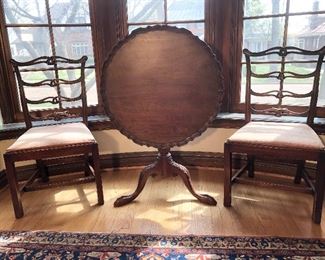Dining Room:  Two of a set of eight antique ribbon back chairs flank an antique mahogany tilt-top pie crust wine/tea table.  The table has a scalloped top; tripod base; and a elongated slipper feet with what appears to be talons (not hairy paws).