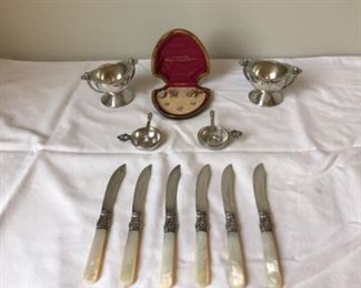 Sun Room-CASE:  A pair of silver-plate salt cellars flank an ART DECO Krementz mother-of-pearl tuxedo stud set in its original box.  Also shown are a pair of GEORG JENSEN sterling salt cellars with tiny sterling spoons and a 6-piece mother-of-pearl fruit knife set.