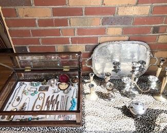 Sun Room:  Collectibles are in the locked glass case to the left of a large "F" monogrammed silver-plate tray; three pairs of weighted sterling silver candlesticks; a silver-plate candelabra; and a silver-plate creamer.  Some closer photos follow.