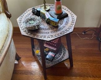 Small table with ornate carving, antique oil lamp