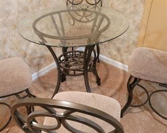 Bar Height Glass Top Table and 4 cloth chairs. Table top 36" x 36" x 35 1/2" H.  Chairs are 25" tall to the seat